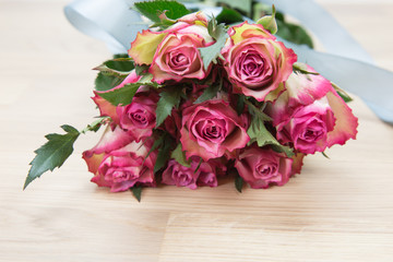 Bunch of beautiful pink roses on wooden background.