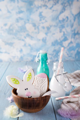 Easter cookies as rabbit and egg in the wooden bowl with milk in glass on wood background