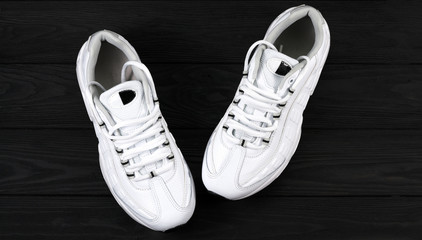 .white sneakers on a black background