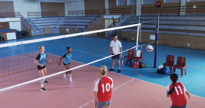 Female players playing volleyball in the court 