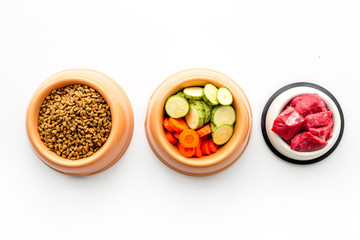 Ingredients for dry pet food. Meat and vegetables zucchini and carrot on white backgroud top view copy space