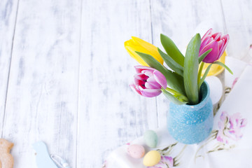 A small bouquet of pink tulips in a blue vase. Easter decor. Free space for text