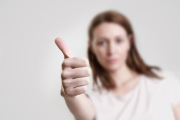 
Studio portrait of young woman giving thumb up