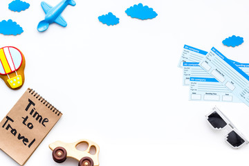 Travelling with child concept. Airplan toy, air balloon cookie, airplan tickets. Time to travel hand lettering in notebook on white background top view copy space