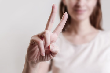 

Studio portrait of young woman showing peace sign