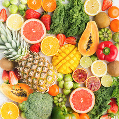 Fruits and vegetables rich in vitamin C background pattern, oranges mango grapefruit kiwi kale pepper pineapple lemon sprouts papaya broccoli, on white table, top view, selective focus