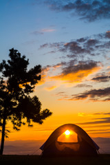Fototapeta na wymiar Orange tent glows under night sky.