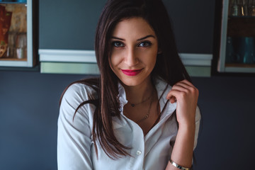 Obraz premium Beautiful brunette girl smiling and looking at the camera