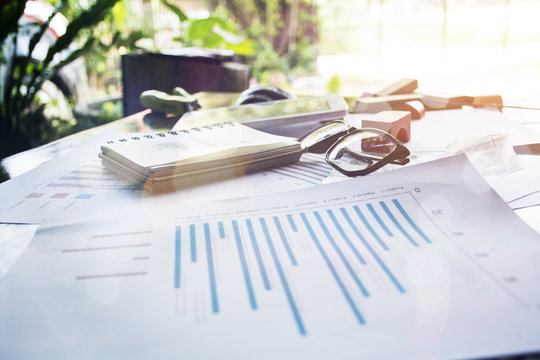 Preparing report. Blue graphs and charts. Business reports and pile of documents on gray reflection background.