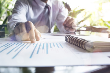 Image of male hand pointing at business document during discussion at meeting