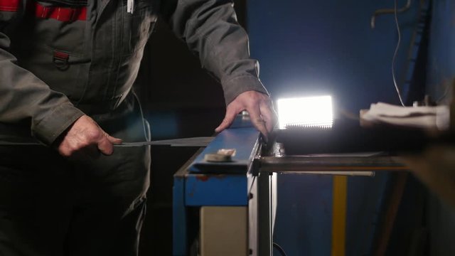 Worker setting a metal blank in a special machine