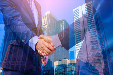 Fototapeta na wymiar Double exposure photo. Photo mix building city and Shake hands. They are join hands mean teamwork and spirit beside building background. Photo concept for business and team work.
