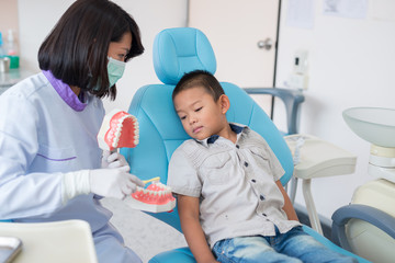 Asian female dentist talking to brush teeth properly explained to the boys were listening to in the hospital