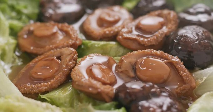 Chinese style cuisine, abalone and mushroom on lettuce
