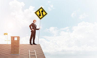 Engineer man on brick roof with sign in hands. Mixed media