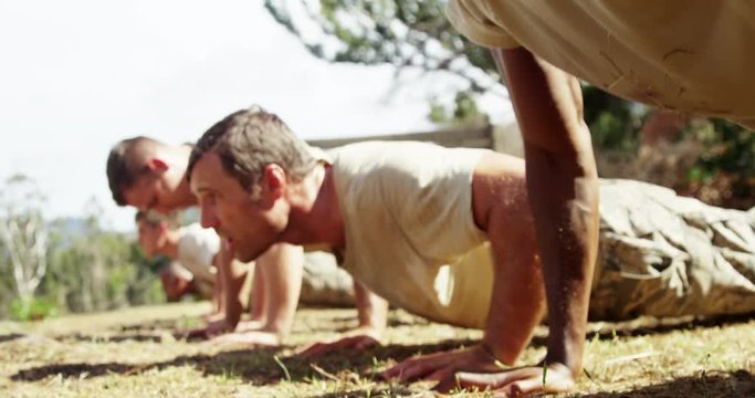 Military soldiers dosing push-ups during obstacle course 