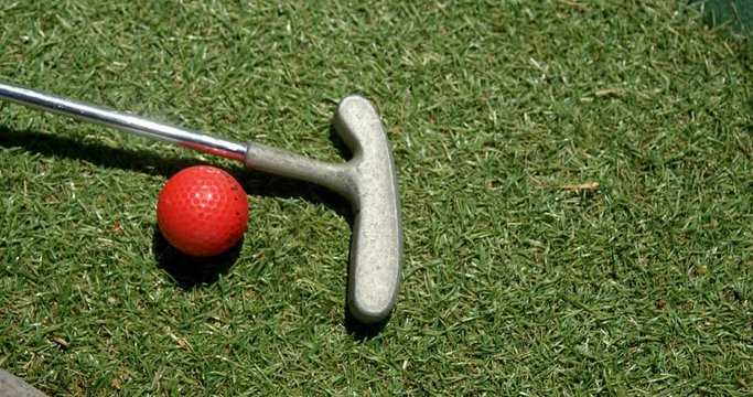Golf putter and golf ball in the garden 