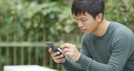 Man use of mobile phone at garden - Powered by Adobe