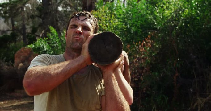 Military troops carrying heavy wooden log during obstacle course 