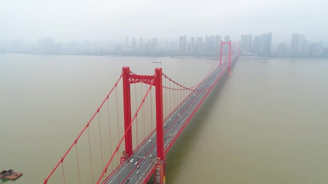 WUHAN, CHINA - MAY 2, 2017: Aerial drone video, red suspension bridge with traffic flowing across