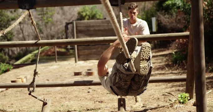 Military soldier crossing the rope during obstacle course 