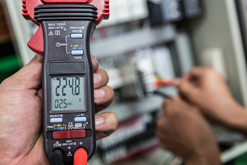 Electrical Engineer is check electrical equipment with a multi-meter
