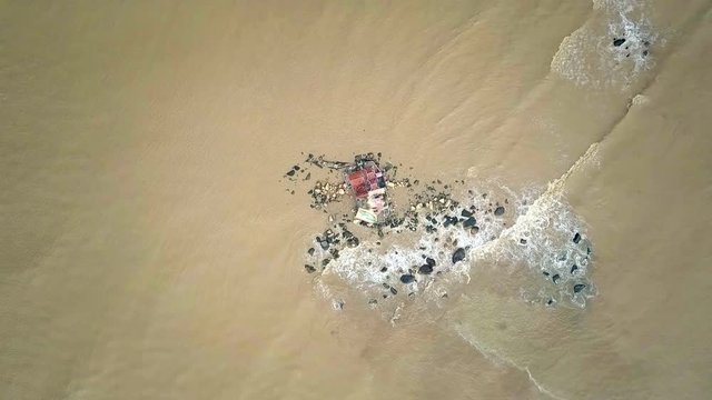 Waves Move by Rolling on Boulders with Temple Aerial View