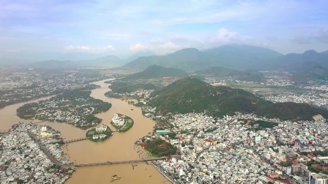 River with Inhabited Islands among City by Hills