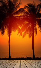 Empty wooden terrace over tropical island beach with coconut palm at sunset or sunrise time