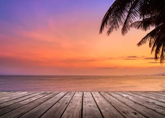 Wall murals Beach sunset Empty wooden terrace over tropical island beach with coconut palm at sunset or sunrise time