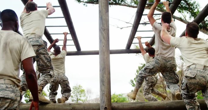 Military soldiers climbing horizontal bars 