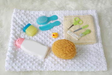 Fototapeta na wymiar Children's bath products and hygiene items on white fur.