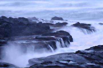 Moody Ocean Seascape landscape on rocky beach with misty waves