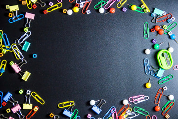 Top view of office table or desk with colorful equipment on black background with copy space for text.