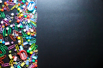 Top view of office table or desk with colorful equipment on black background with copy space for text.