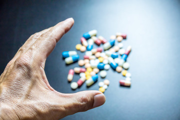 Medicine on hand with colorful medicine black background