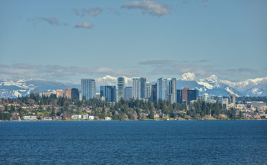 Fototapeta na wymiar Bellevue, Washington and Cascade Mountains Shine on a Sunny Afternoon across from Lake Washington