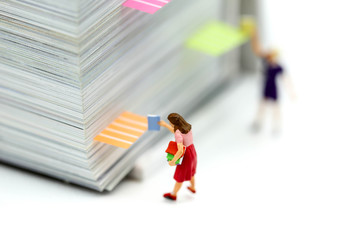 Naklejka premium Miniature people : reading stand on book using as background education or business concept.