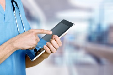 Young man doctor holding digital tablet