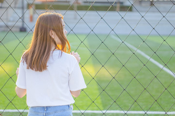 Stress. Protrail stressed sad young woman sticking with  iron net of tennis court, Negative human...