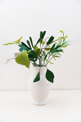 Crepe paper leaves bouquet with mistletoe and eucalyptus in a vase