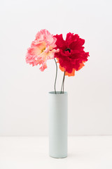 Crepe paper poppies in a vase on white