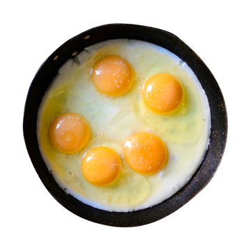 Appetizing fried several eggs in a cast-iron frying pan isolated on white