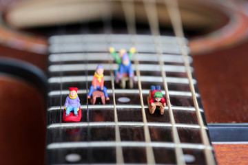 Miniature people : Child  having fun to play slider with acoustic guitar,time of relax or music...