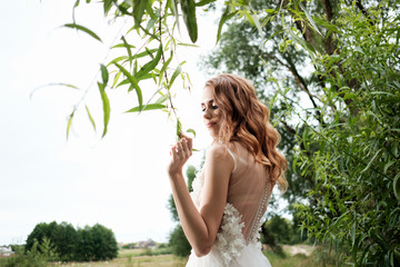 young pretty bride in white wedding dress outdoors, make up and hairstyle