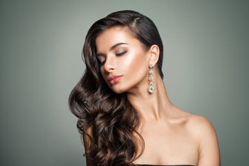Naklejka premium Beautiful Female Model. Perfect Makeup. Wavy Hair. Jewelry Earrings