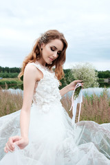 young pretty bride in white wedding dress outdoors, make up and hairstyle