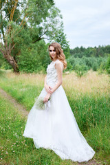 Fototapeta na wymiar young pretty bride in white wedding dress outdoors, make up and hairstyle