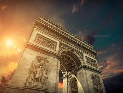 Arc de Triomphe in Paris under sky with clouds. One of symbols o