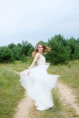 Fototapeta na wymiar young pretty bride in white wedding dress spin around